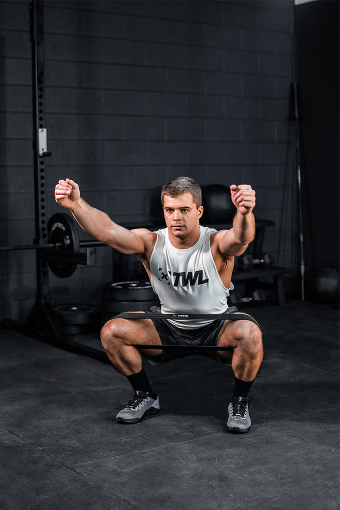 athlete doing banded air squat