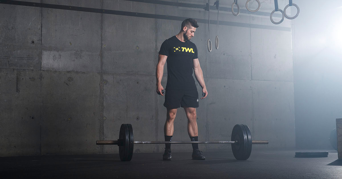 athlete standing over barbell