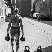 female athlete carrying kettlebells