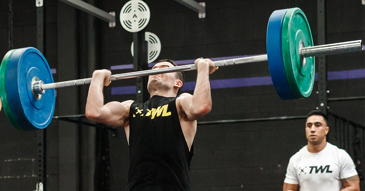 male athlete performing thruster