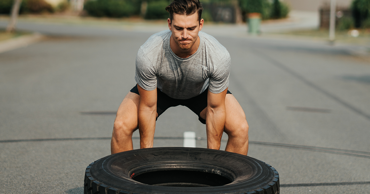 male athlete flipping tire