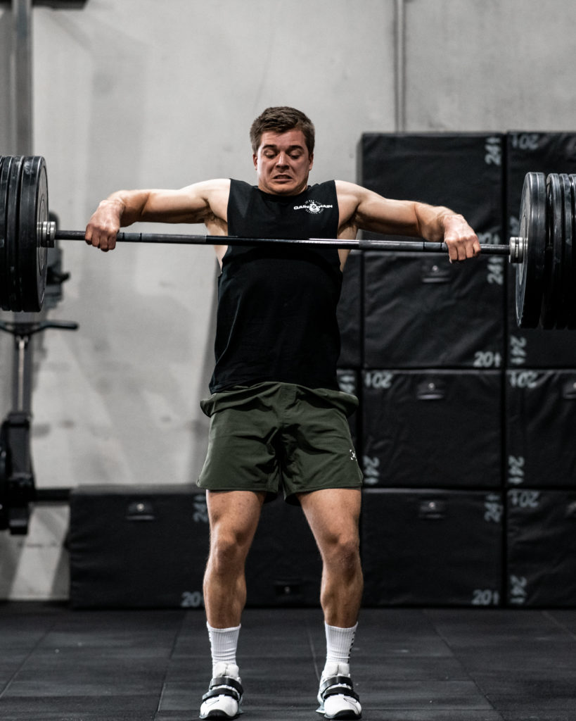 male athlete doing high pull in olympic weightlifting shoes