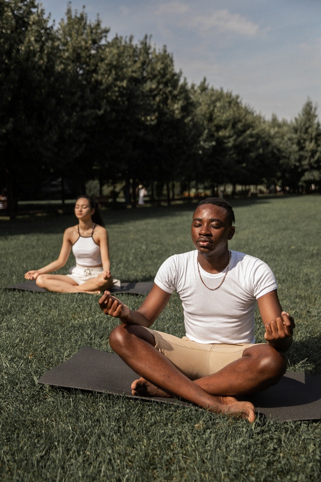 two people meditating outside