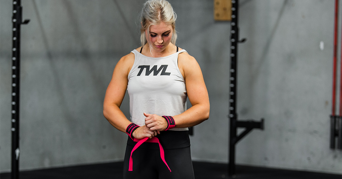 female athlete putting on wrist wraps