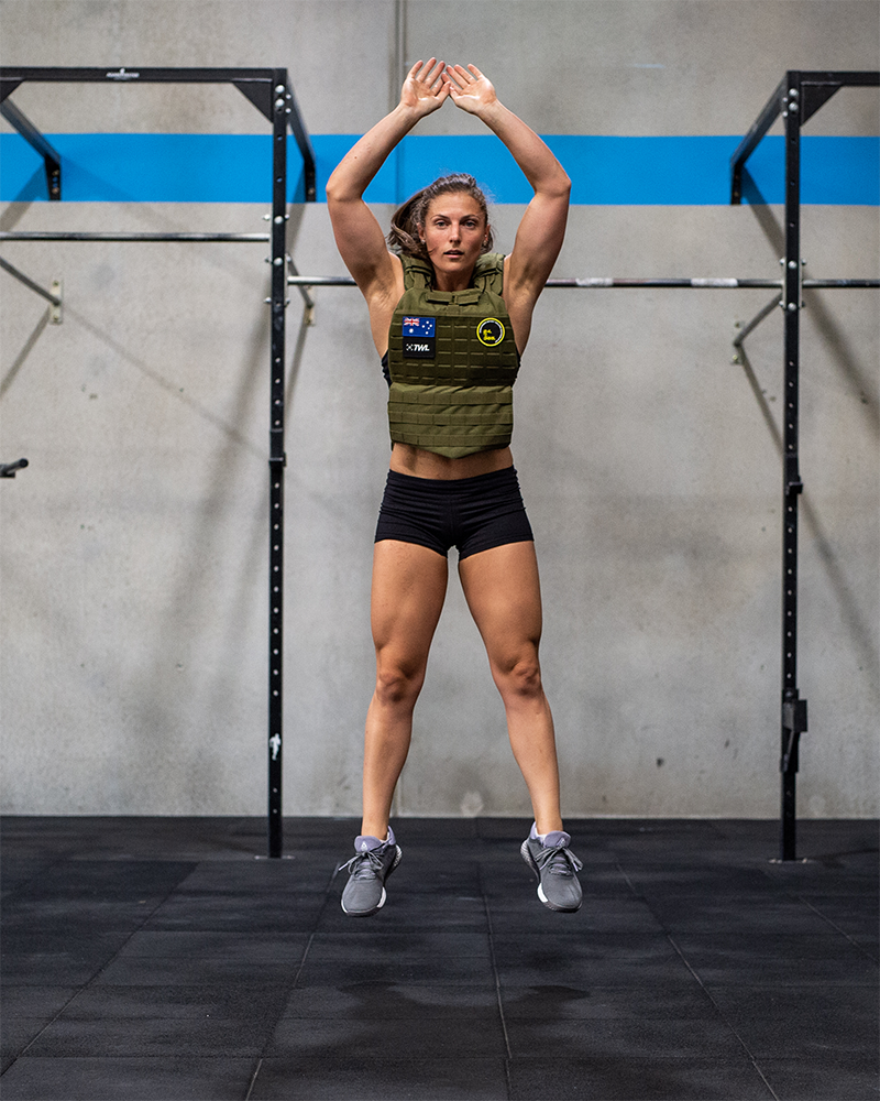 female athlete doing burpees in a weighted vest