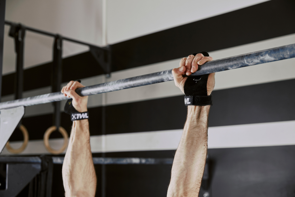 athlete on pull-up bar wearing hand grips